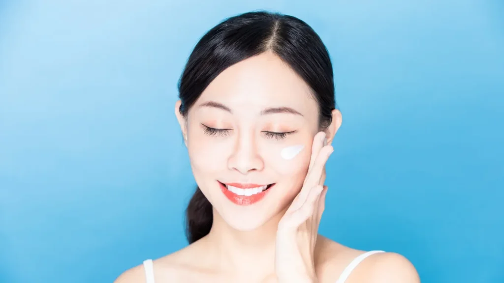 Woman applying SPF sunscreen to her face